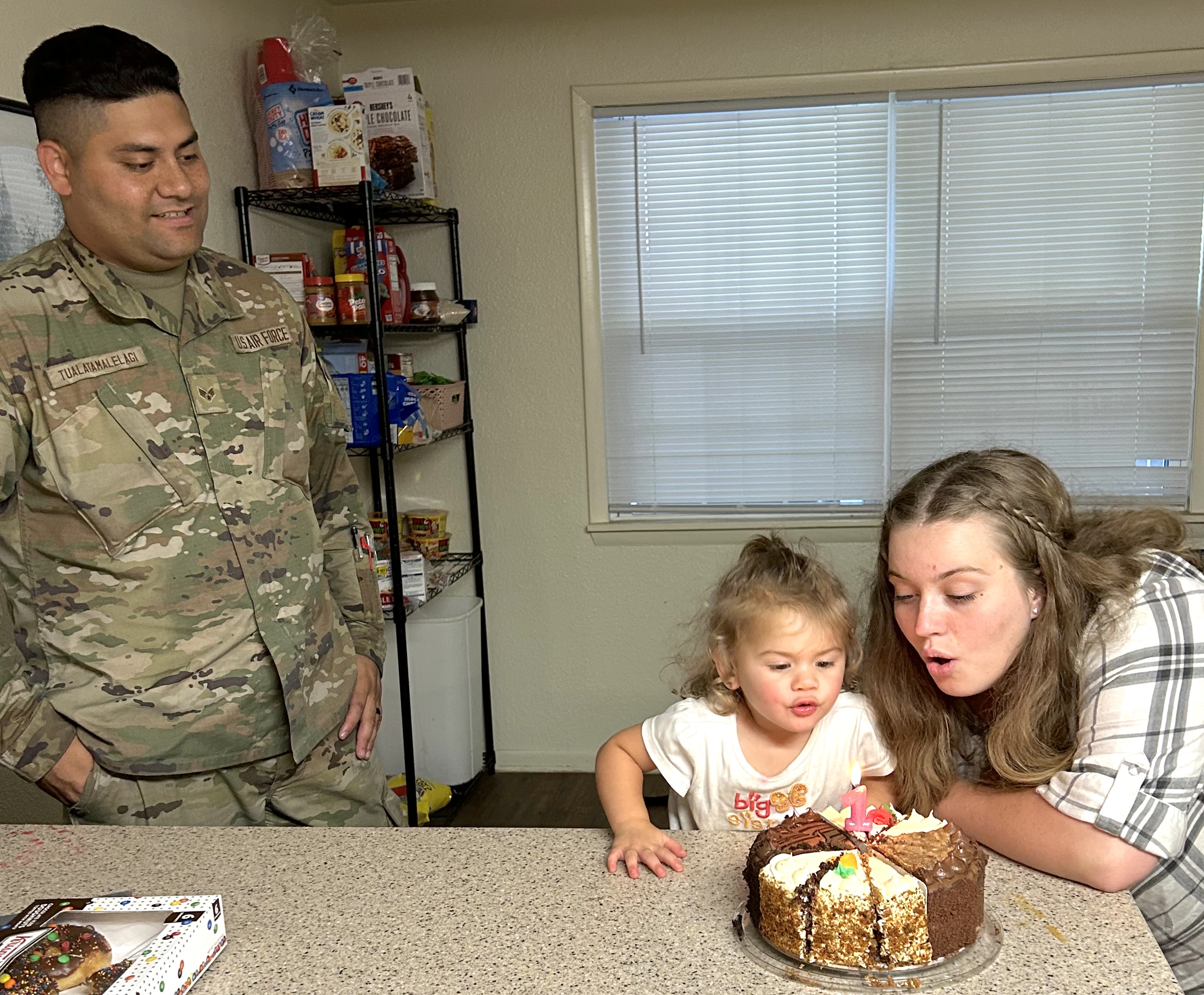 Tauai Tualatamalelagi looks on as his wife Alyssa and daughter blow out the candle for her one-year birthday