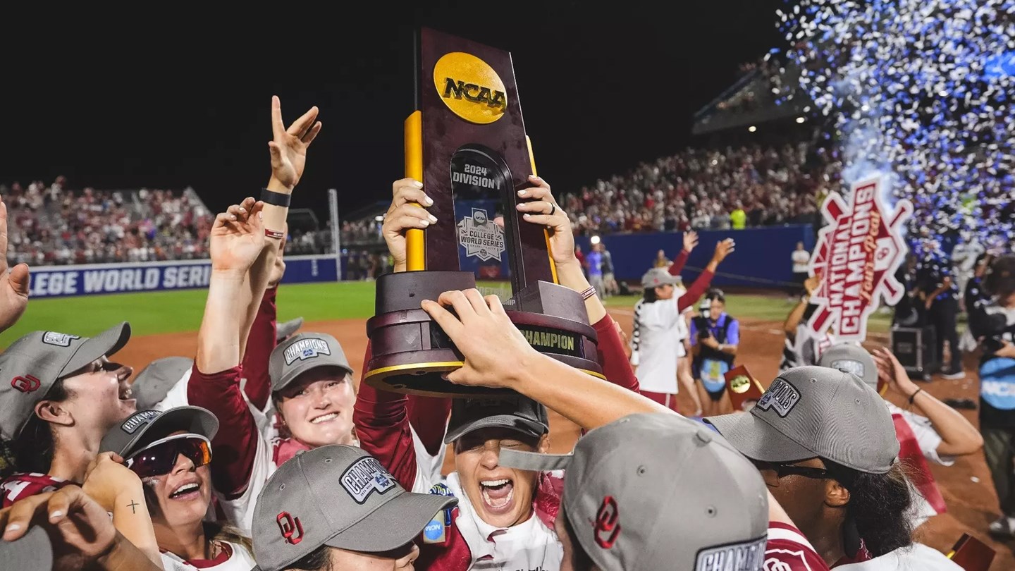 The Sooners teams holds aloft the 2024 NCAA D1 Championship trophy. Photo by Big 12 Sports