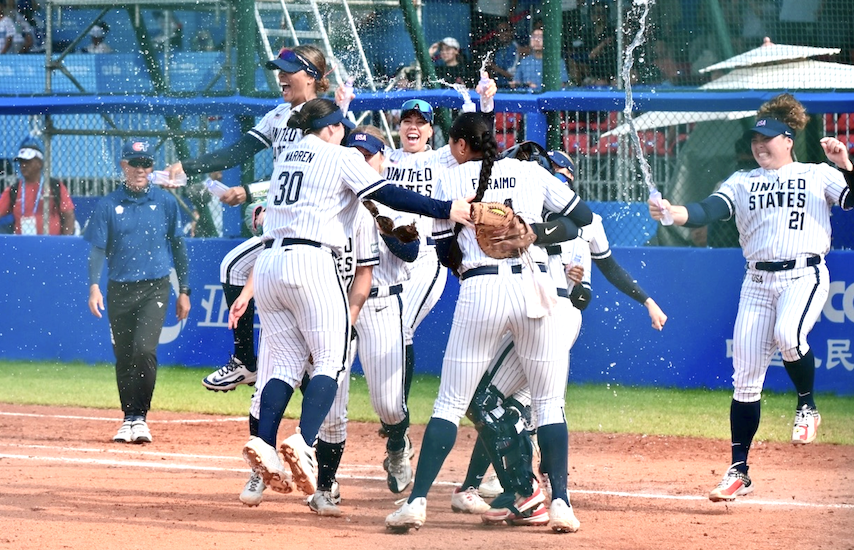 Team USA members celebrate after Megan Faraimo pitched a masterful 5-0 shutout performance by Megan Faraimo to clinch the Americans fourth consecutive gold medal at The World Games. Photo by WBSC.