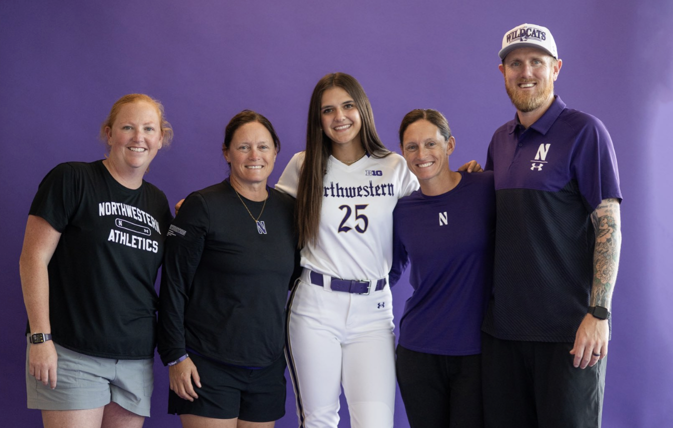 Harper Lohse, a 2027 pitcher with St. Louis Chaos, poses with the Northwestern coaching staff on her official visit.jpg