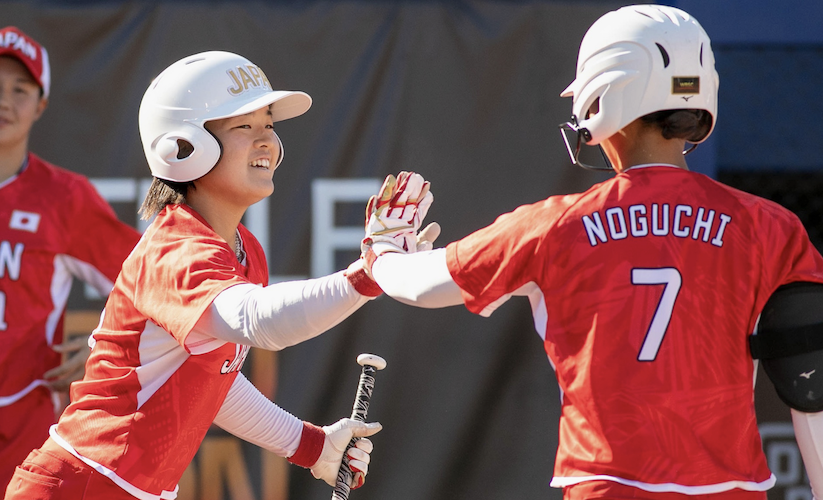 Outfielder Magae Noguchi (right) high-fives a teammate after scoring one of Japan's five runs in the win over China