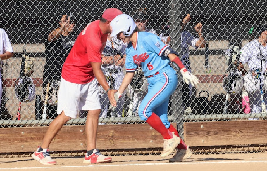 Rachel Grundei, an outfielder committed to Illinois, gets a low five after hitting a home run for her Texas Blaze United - Robertson team.j