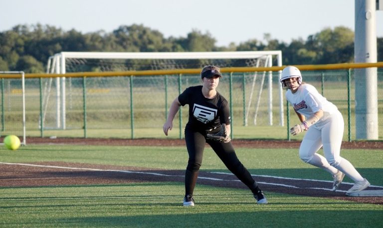 Ashlyn, seen here playing first base, struggled with negative self-talk but was able to transform her "negative tendencies from negative to positive" with the help of her then club coach, Ron Schmittling.